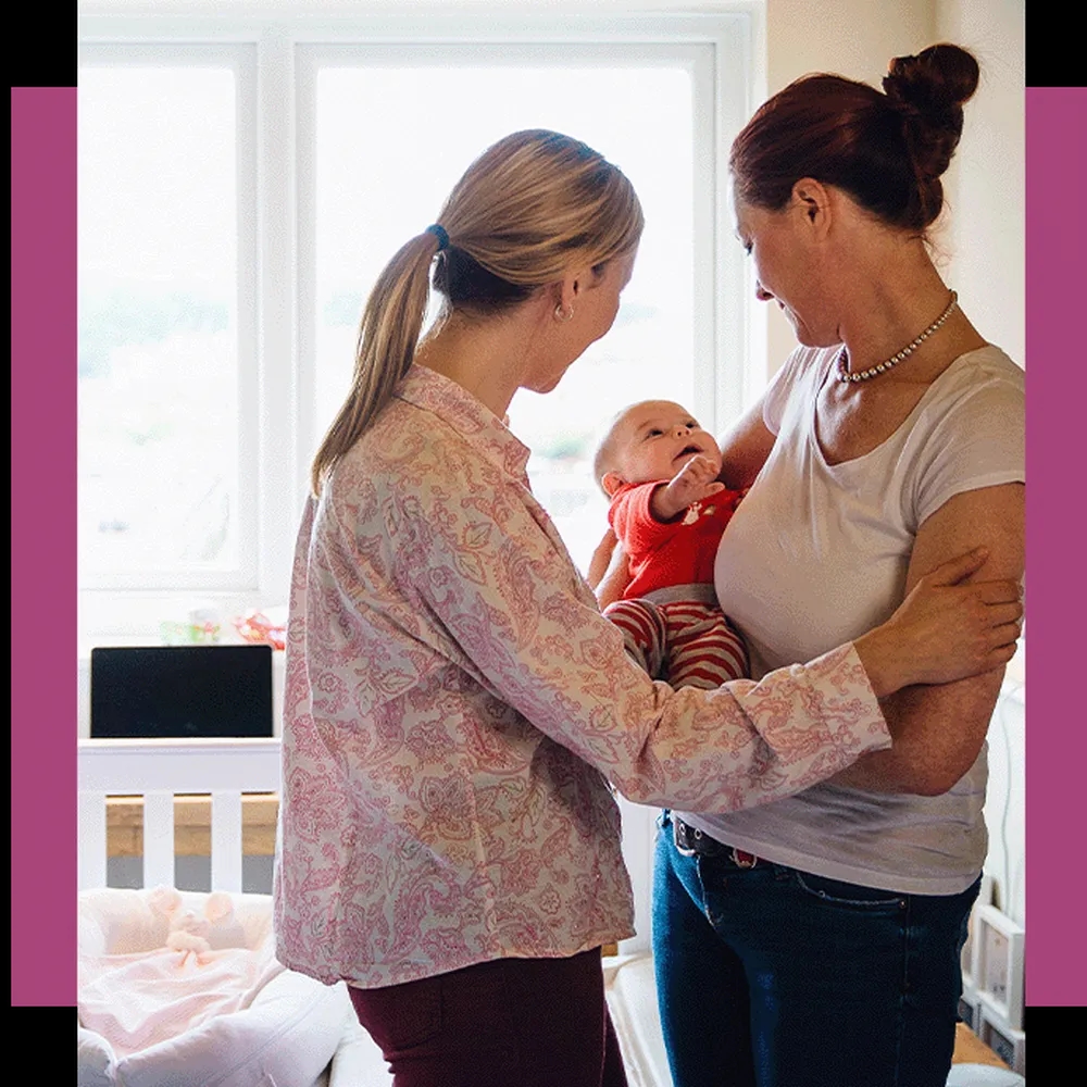 Two women holding a baby